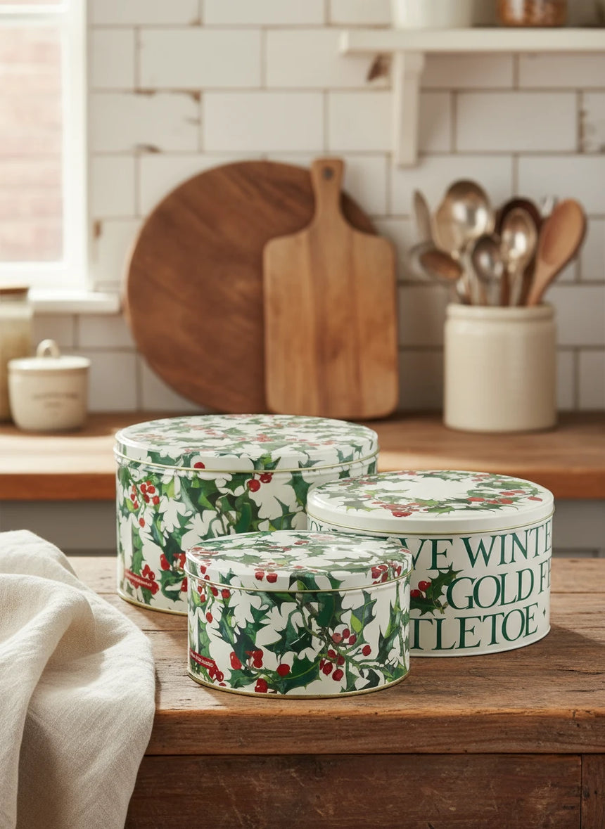 Set of three decorative tins with floral and text design on a white background