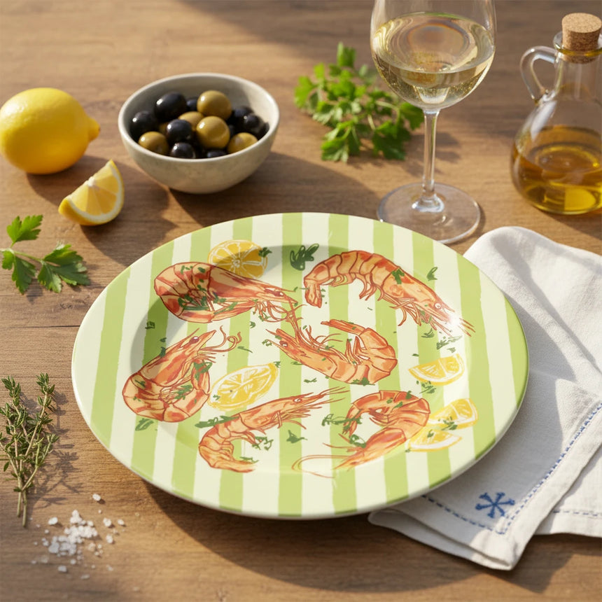 Round plate with shrimp and lemon design on a green and white striped background