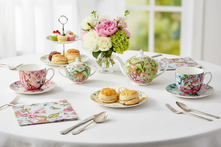 Set of four floral teacups and saucers on a white background