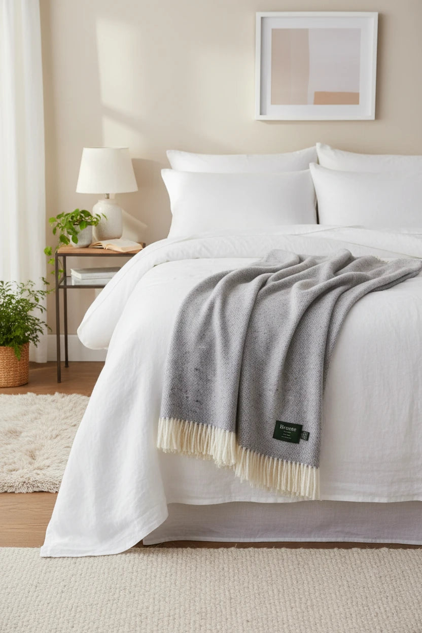 Light blue textured throw blanket with white fringe and Bronte label on a white background
