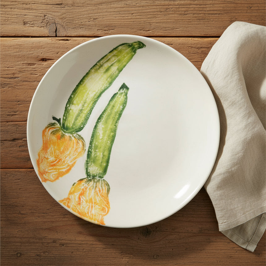 Round ceramic plate with illustrations of zucchinis on a white background