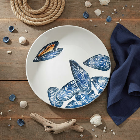 Round ceramic plate with blue mussel shell design on a white background