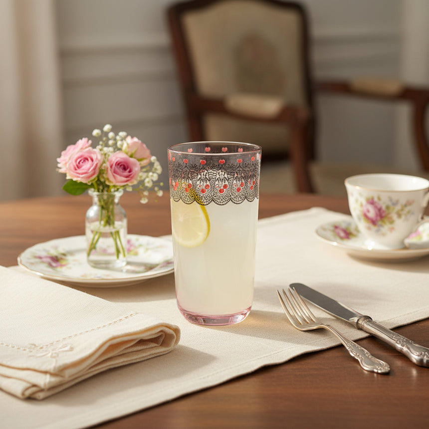 A clear acrylic high ball tumbler with a vintage floral pattern featuring a cherry motif and intricate flowers, with a pink hue at the base and a decorative pattern at the top.