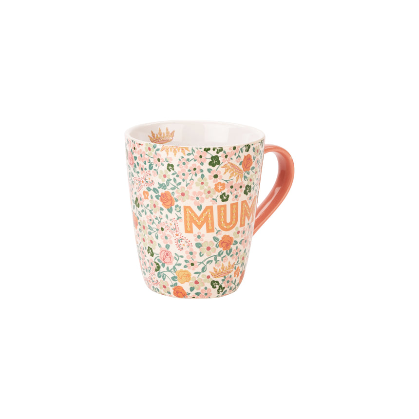 A ceramic mug with a dense floral pattern in pink, orange, and green on a white background, featuring the word 'MUM' in orange letters and a terracotta-colored handle.
