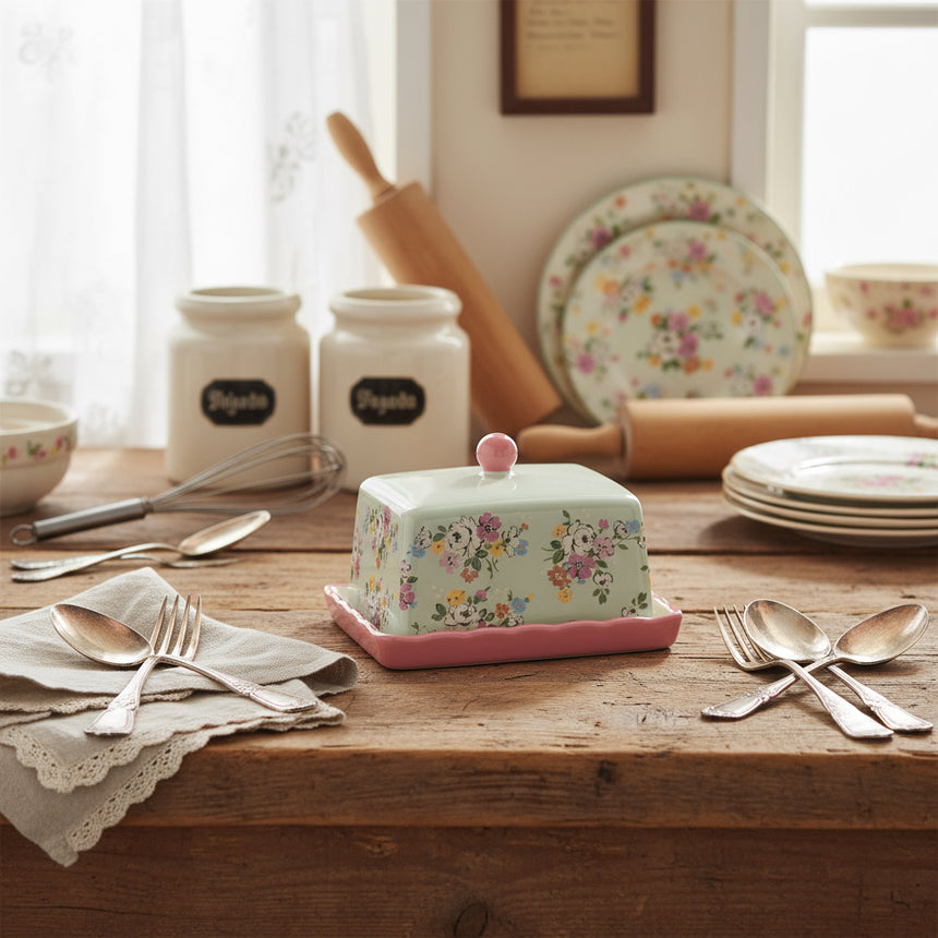 Floral-patterned butter dish with pink base on a white background