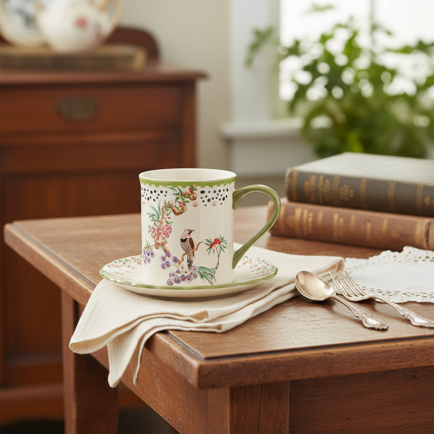 A Cath Kidston stoneware mug with a green handle and floral patterns, accompanied by a matching coaster.