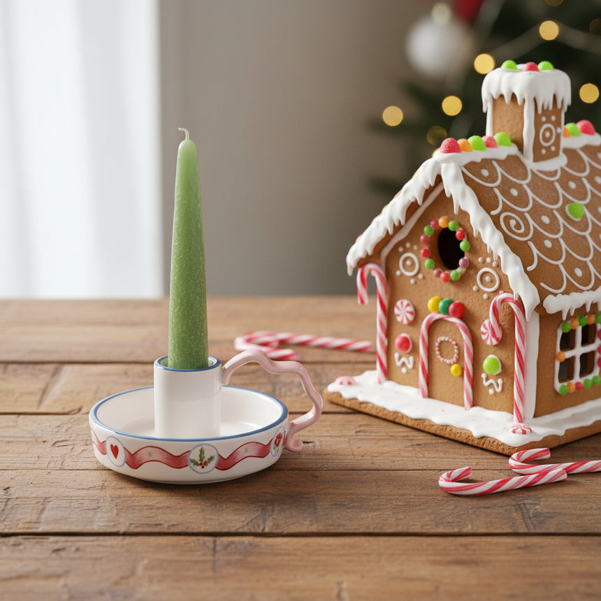Ceramic candle holder with decorative handle on a white background
