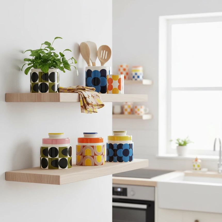 Three ceramic jars with colorful geometric patterns on a beige background