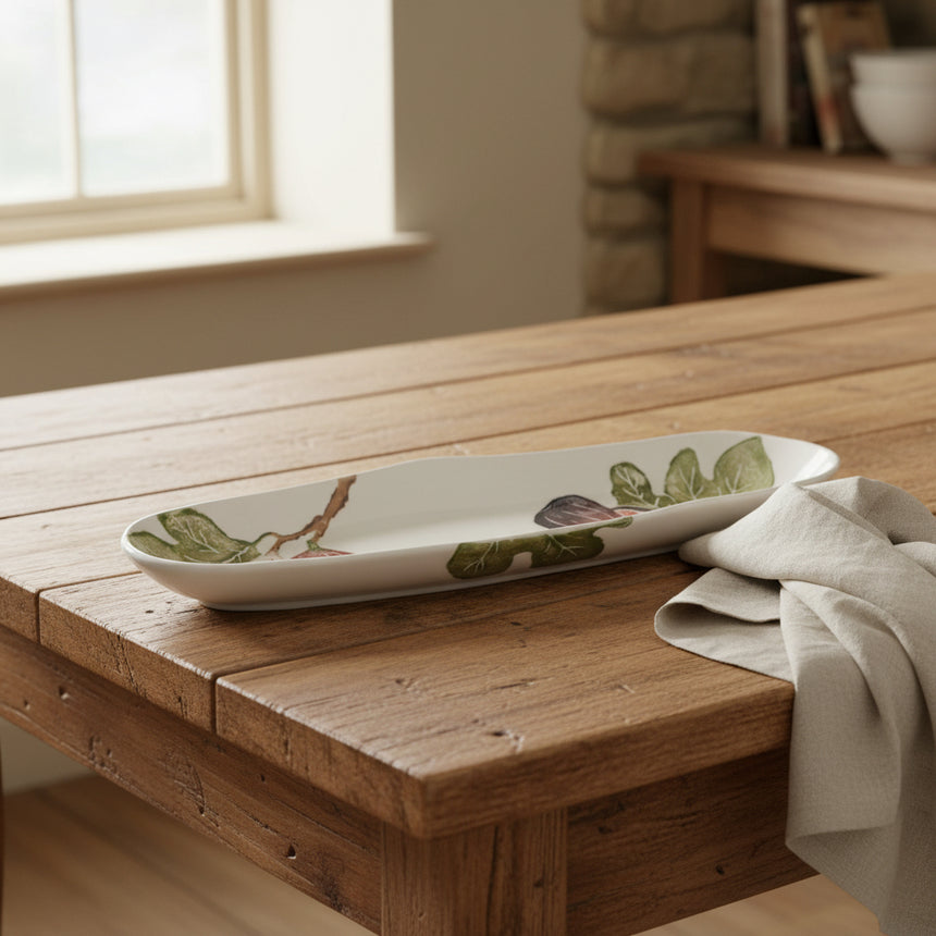 Long white ceramic platter with fig illustrations on a white background