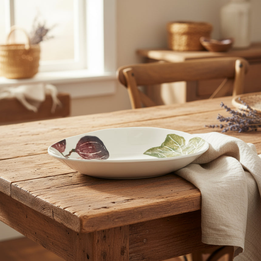 White ceramic bowl with fig and leaf design on a white background