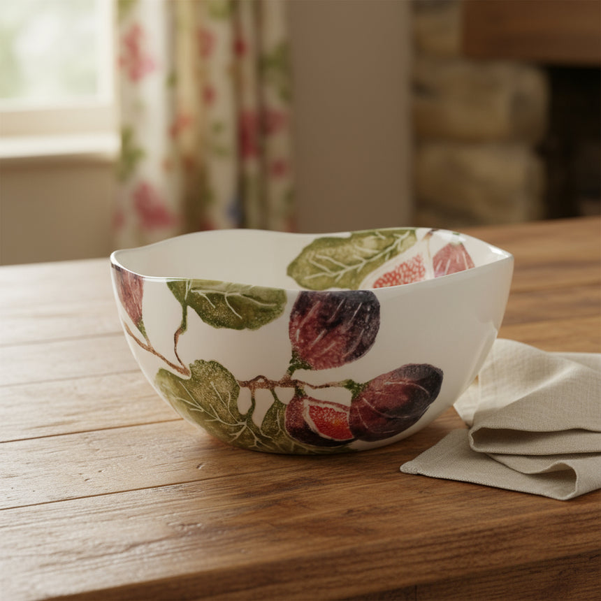 A large serving bowl with a hand-printed illustration of fig fruits on a white background, earthenware material, with a floral pattern and reactive glazes techniques.
