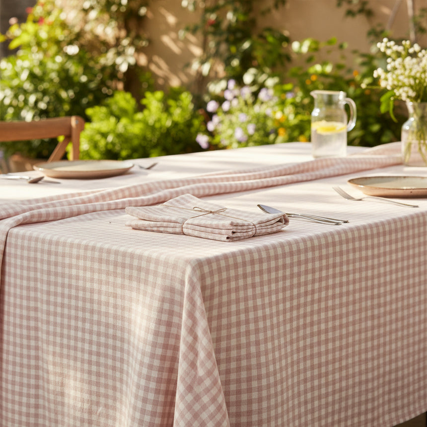 Folded checkered tablecloth with a pink and white pattern on a white background