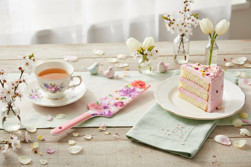 Floral-patterned cake server with pink handle on a white background