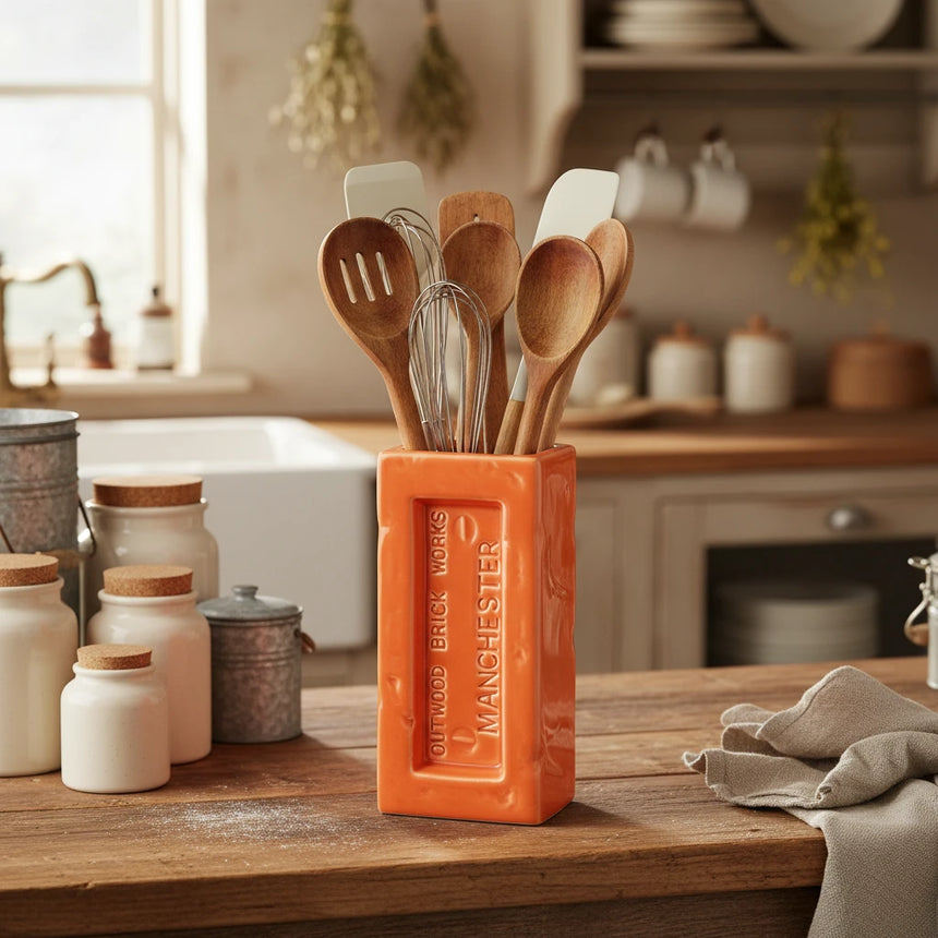 Orange brick-shaped vase with 'Outwood Brick Works Manchester' text on a white background