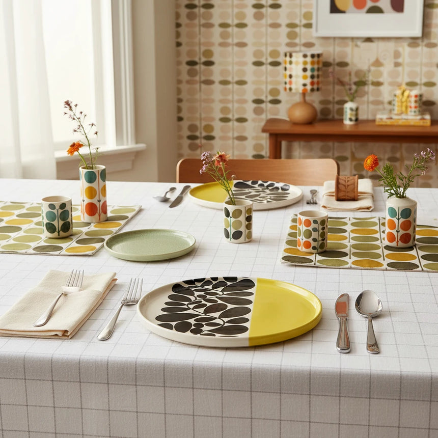 Round ceramic tray with black floral pattern and yellow accent on a beige background