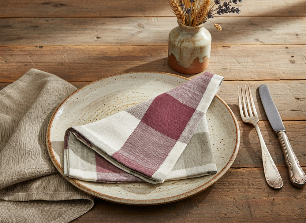 Folded checkered fabric napkin  with red, white, and beige pattern on a white background