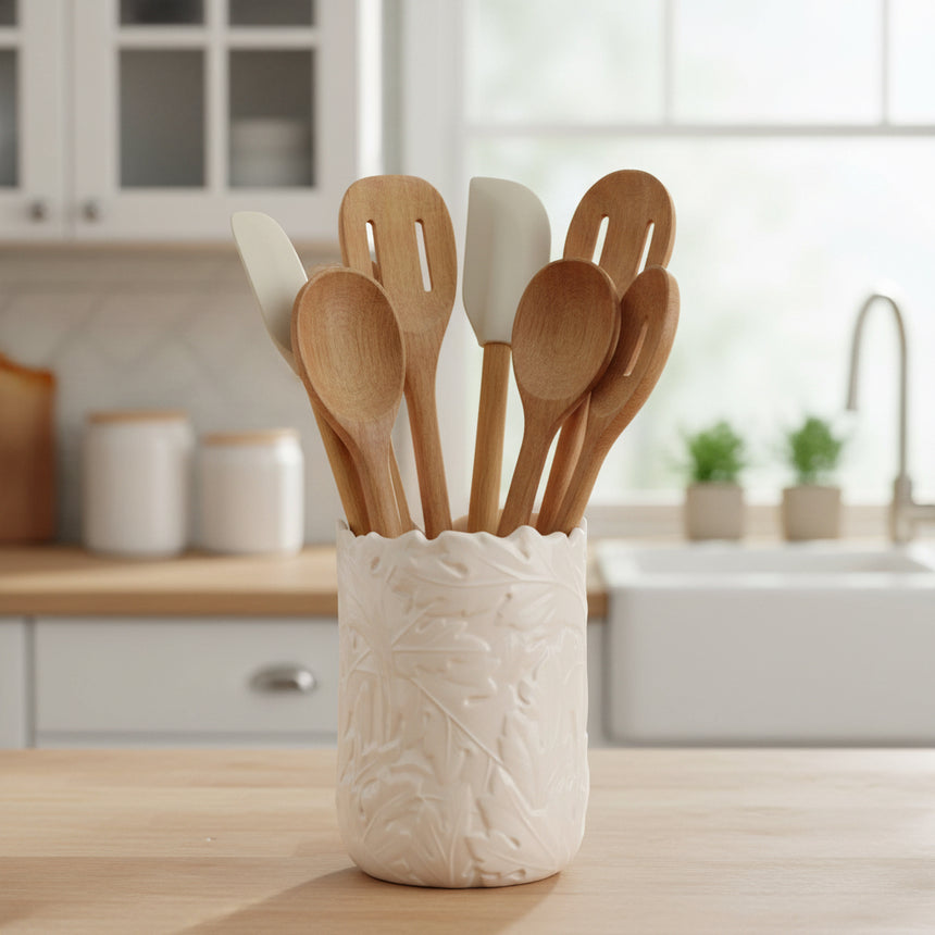An off-white ceramic utensil holder with a textured, embossed leaf pattern and a scalloped rim, shown on a plain white background.