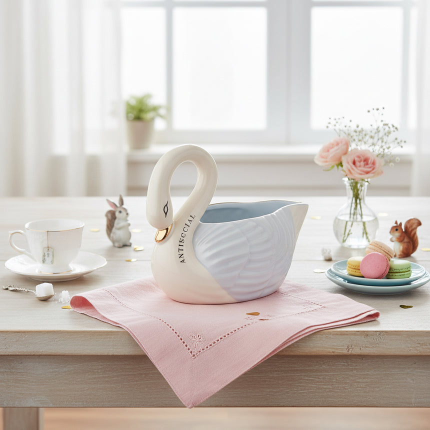 White swan-shaped gravy boat with a blue interior on a white background