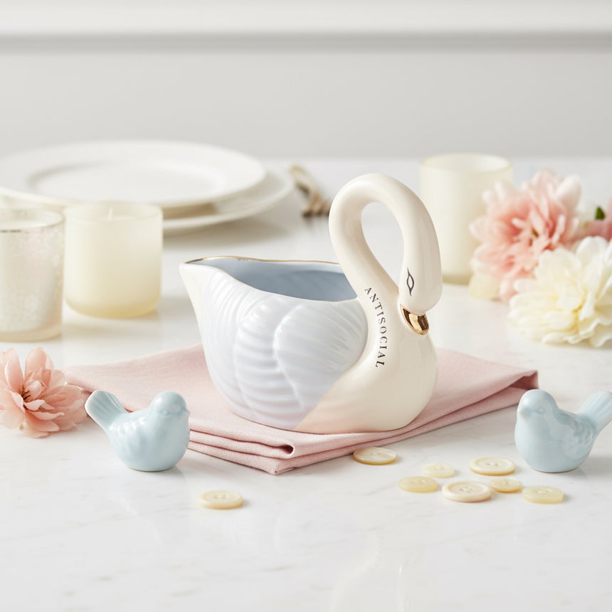 White swan-shaped gravy boat with a blue interior on a white background