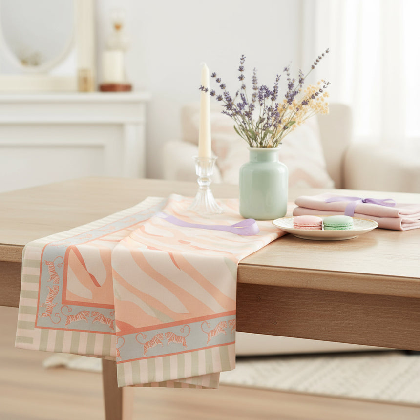 A folded Yvonne Ellen Tiger Cotton Tablecloth featuring a geometric pattern with stripes and a tiger print in pastel colors.