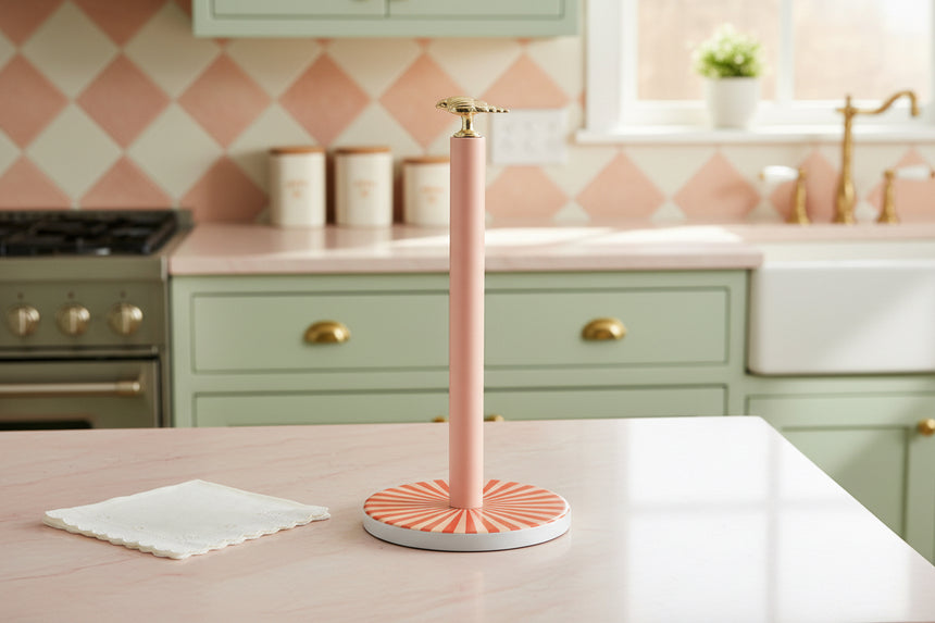 Pink paper towel holder with a red circular base on a white background