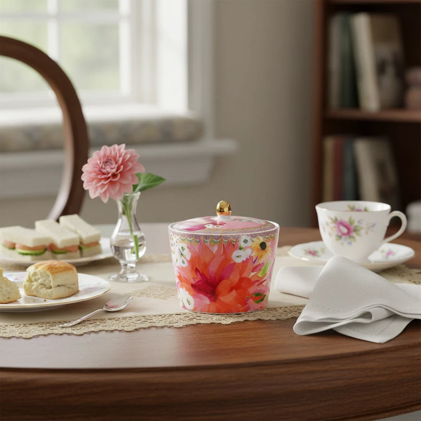 Sugar bowl with floral design and gold knob lid on a white background