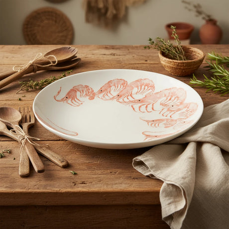 White platter with pink shrimp illustrations on a white background