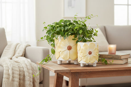 Two ceramic planters with yellow floral designs on a white background