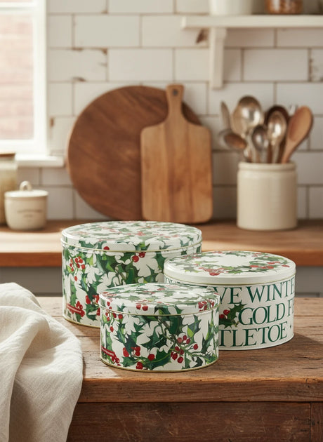 Set of three decorative tins with floral and text design on a white background