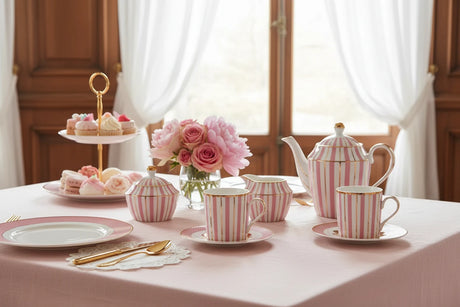 Two pink striped espresso  mugs with gold accents on matching saucers.