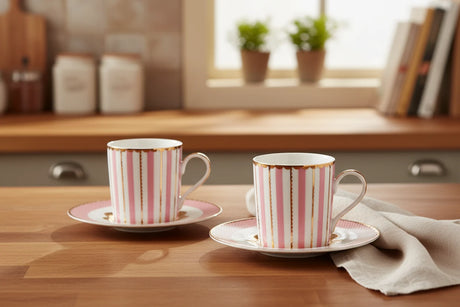 Two pink striped mugs with gold accents on matching saucers.