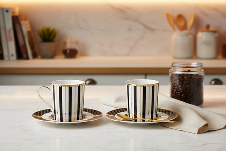 Two black and gold striped coffee cups with saucers on a white background
