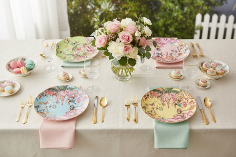 Four round ceramic plates with floral and butterfly designs on a white background
