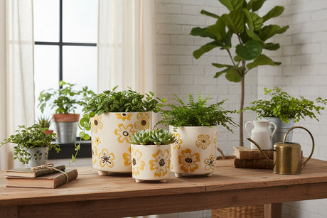 Set of three ceramic planters with yellow floral patterns on a white background