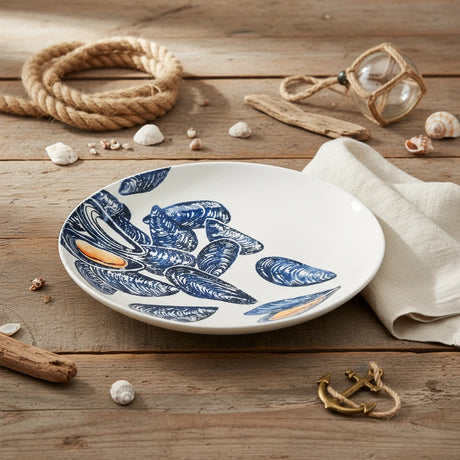 Round ceramic plate with blue mussel shell design on a white background