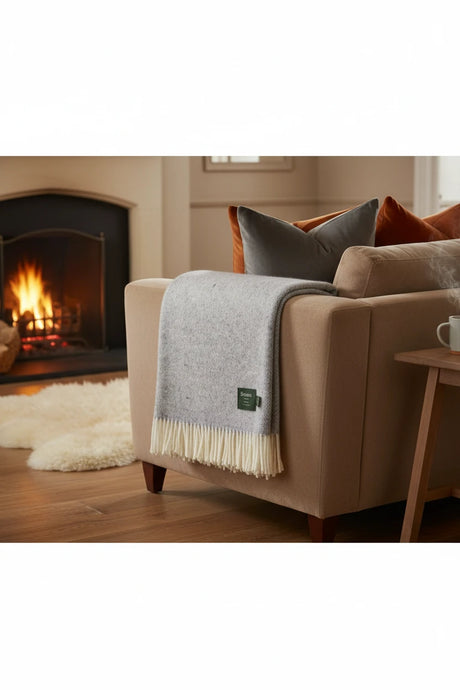 Light blue  textured throw blanket with white fringe and Bronte label on a white background