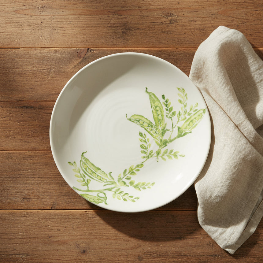 Ceramic plate with green pea design on a white background