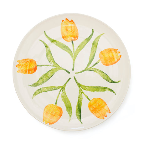 Round ceramic plate with orange tulip design on a white background