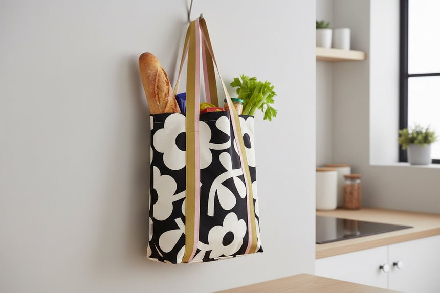 Tote bag with floral pattern and striped handles on a white background