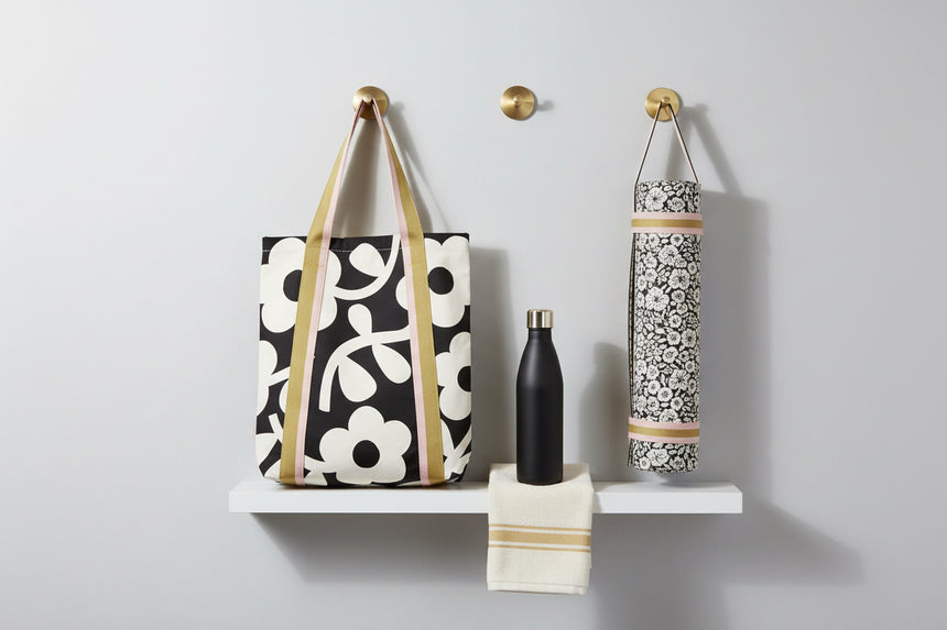 Tote bag with floral pattern and striped handles on a white background