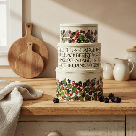 Set of three stacked cake storage tins with berry design and text on a white background