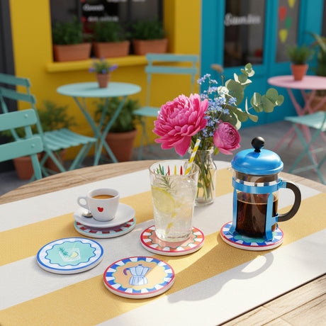 Set of colorful coasters with illustrations on a yellow and white striped tablecloth.