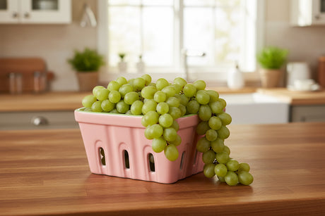 Pink ceramic basket with green rim on a white background