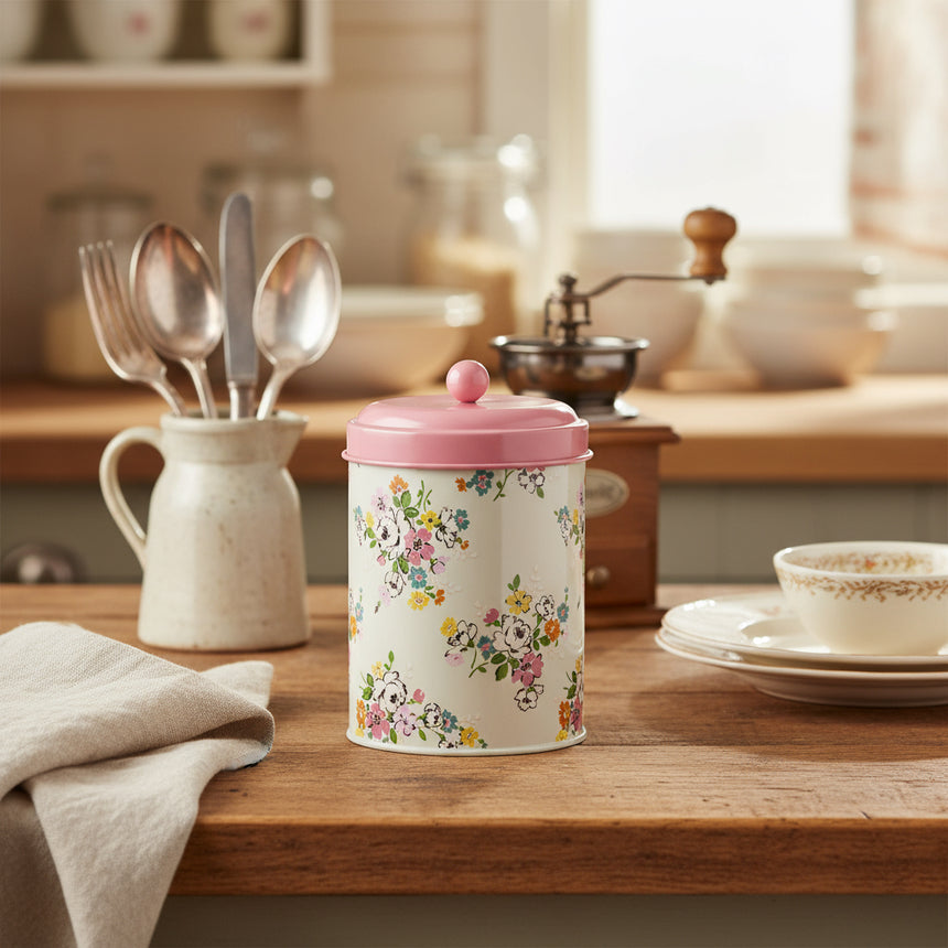Floral-patterned canister with a pink lid on a white background