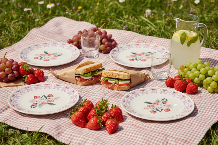 Four round melamine plates  with floral designs on a white background