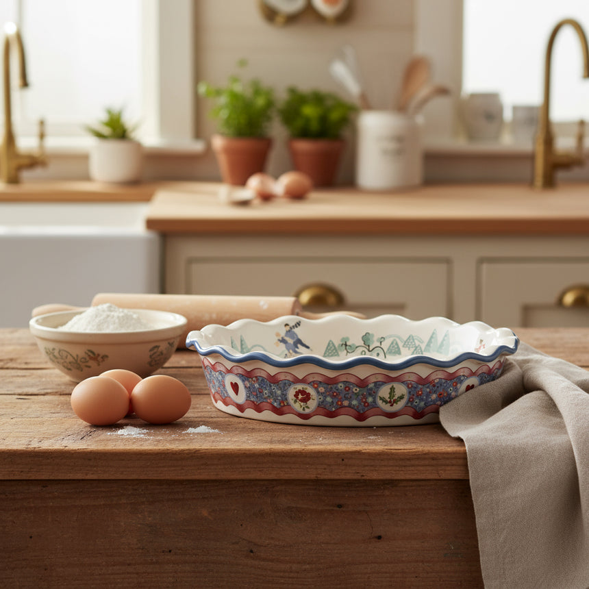 Decorative ceramic pie dish with floral and heart pattern on a white background