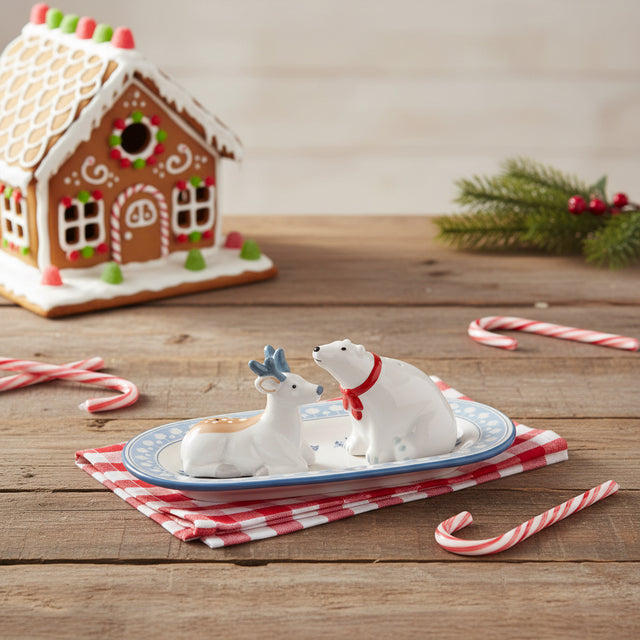 Two white animal figurines on a decorative plate with a white background