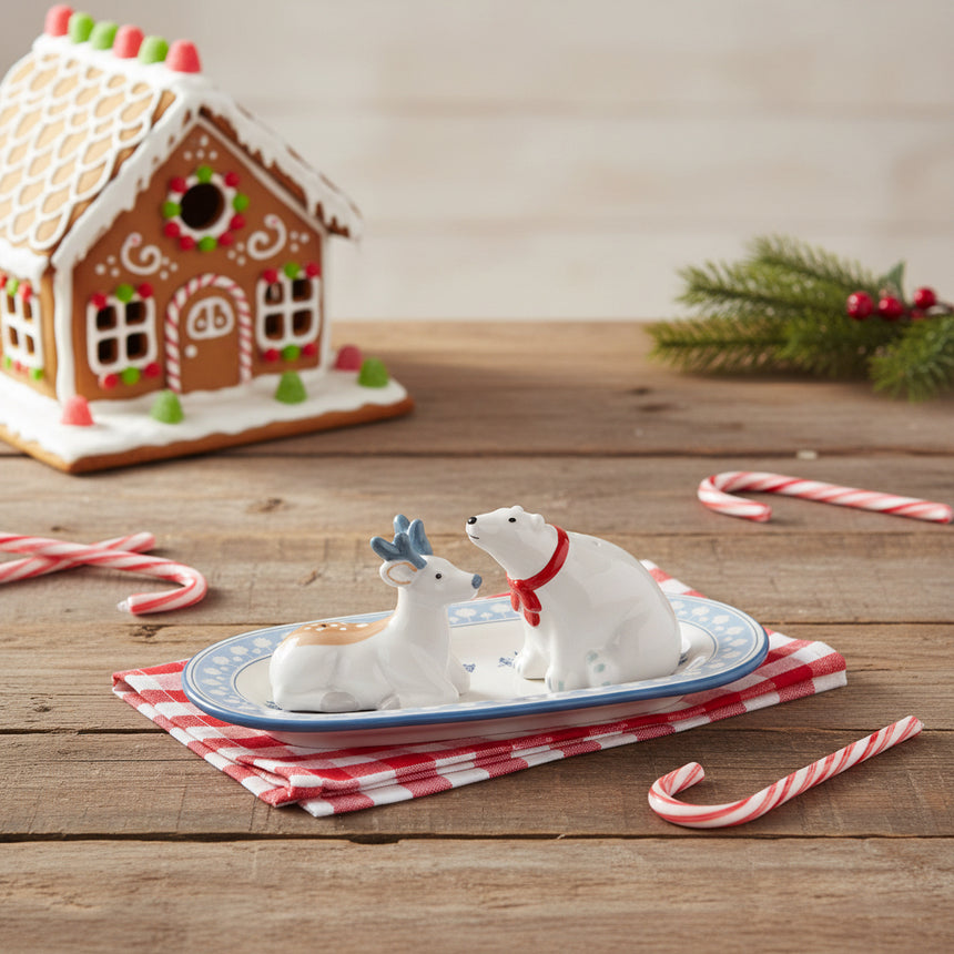 Two white animal figurines on a decorative plate with a white background