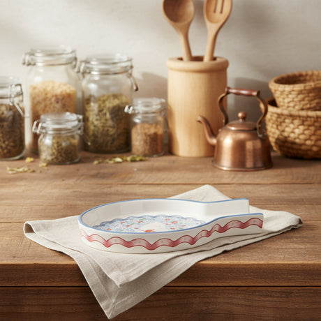 Decorative ceramic  spoon rest with floral pattern on a white background