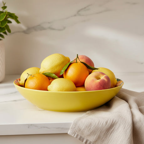 Yellow bowl with floral and fruit design on a beige background